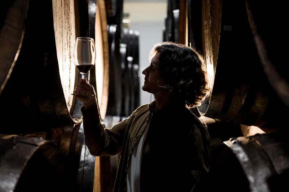 Vue latérale d'un homme regardant un verre de vin